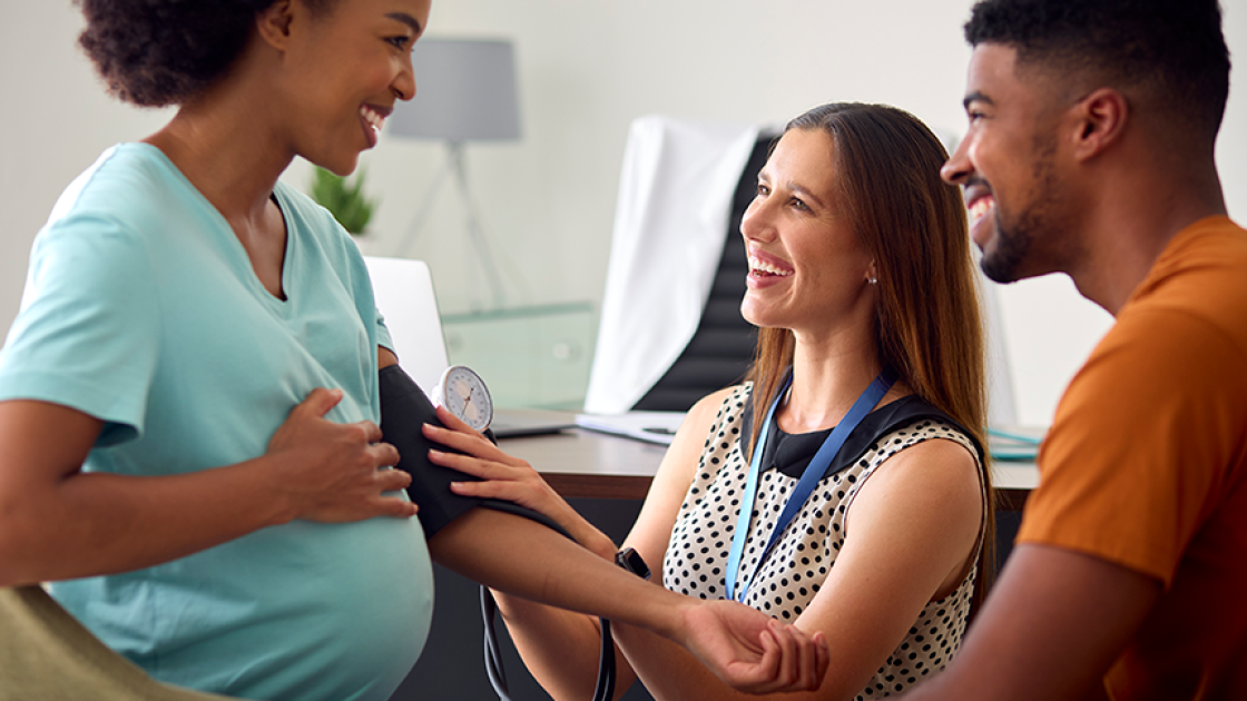 Pregnant woman getting blood pressure checked with husband