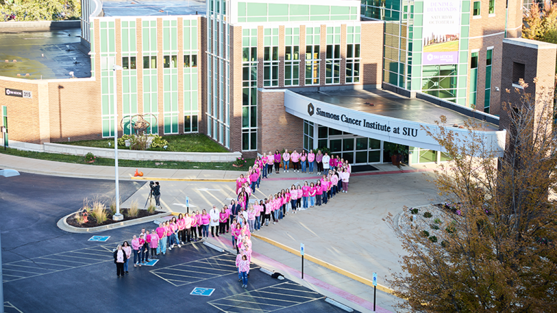 Simmons Cancer Institute pink ribbon of people in parking lot