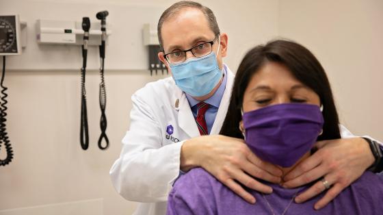 Doctor using his hands to examine a patients neck and throat