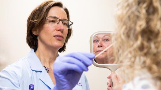 Doctor using a swap to collect a skin sample from her patient