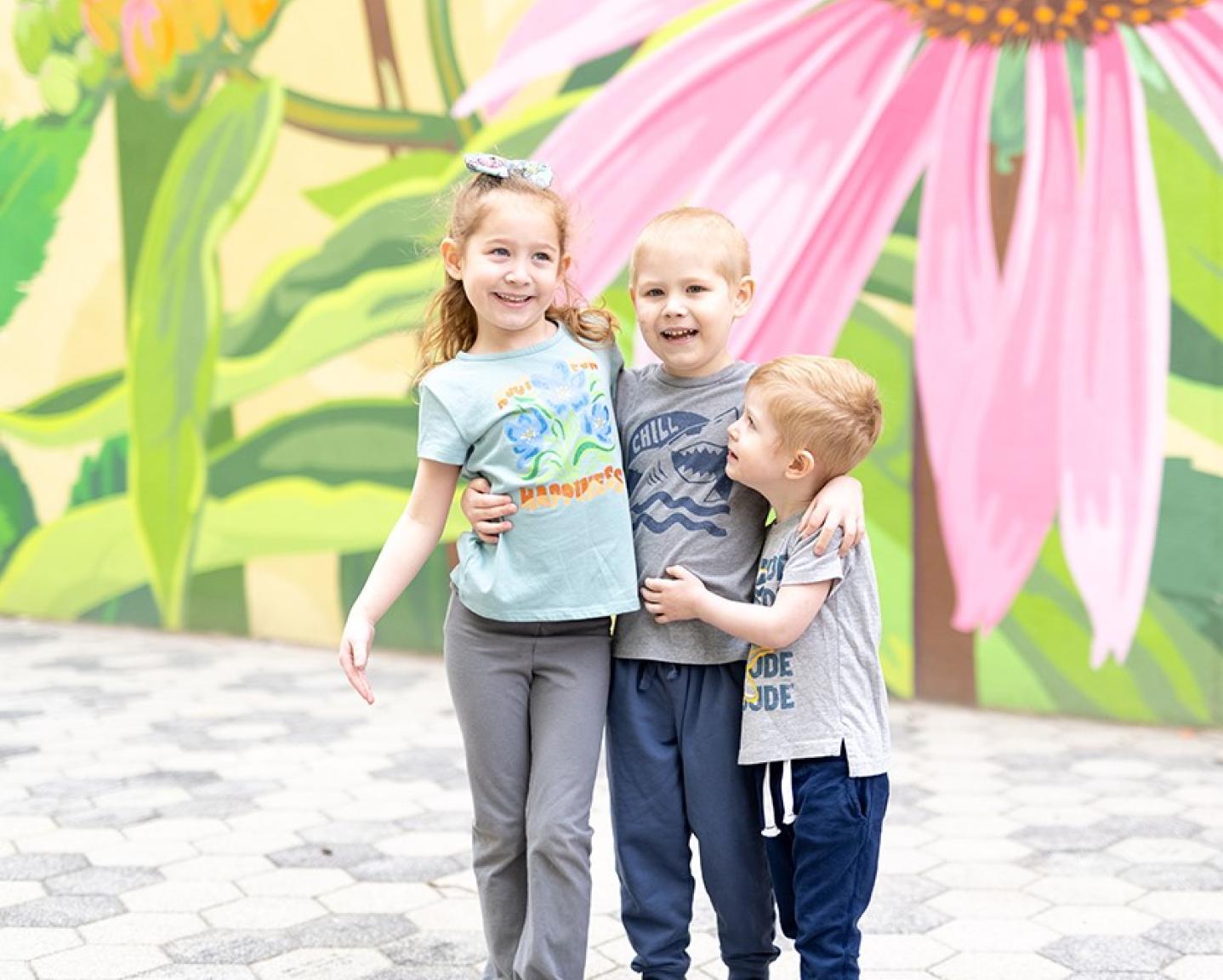 Cal with Remy, Cooper in front of a mural