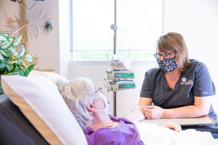 Nurse watching over a patient who is laying in a hospital bed